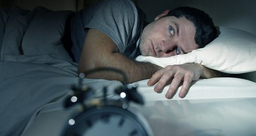 Man waking up with alarm clock